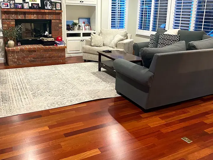 A tidy living room with a fireplace and clean wood floors